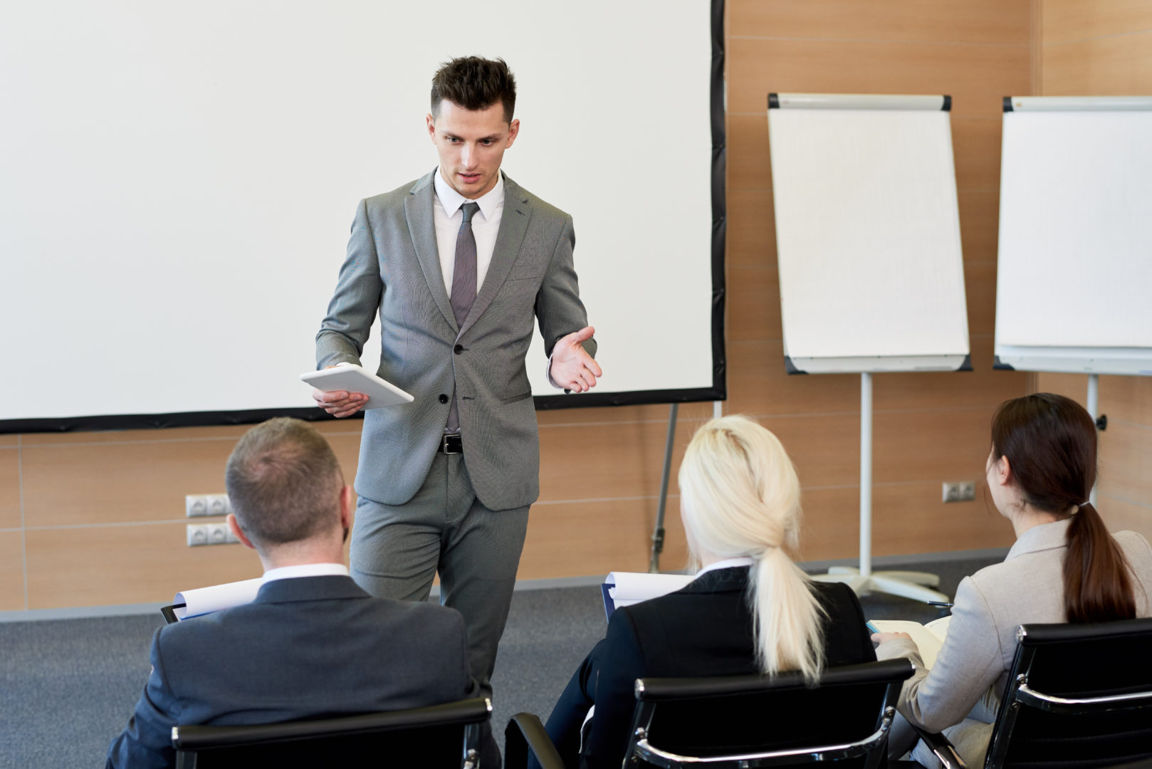 Business Coach in Training Seminar Portrait of handsome successful businessman answering questions from audience during training seminar, copy space